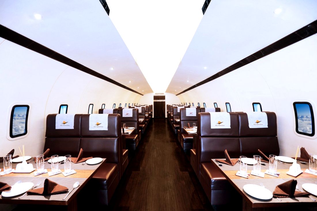 Aircraft-cabin dining room at Fly Kouzina with leather booths and window views